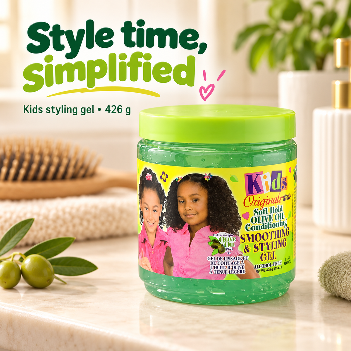 A jar of Kids Originals Soft Hold Olive Oil Conditioning Smoothing & Styling Gel sits on a marble countertop with styled haircare props, including a brush, olives, and a soap dispenser. The jar has a bright green lid and a colorful label showing two young girls with styled hair.
