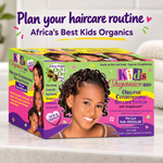 A retail display box of Kids Organics Organic Conditioning Relaxer System on a white marble countertop with a blurred kitchen background. The packaging is highly colorful with lime green, purple, and pink sections, featuring a smiling young girl with styled braids on the front.
