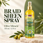 A bottle of African Pride Olive Miracle Braid Sheen Spray stands on a stone slab with olives and green leaves in the background. Large text on the left reads 'BRAID SHEEN SPRAY' with the product name and volume shown below.