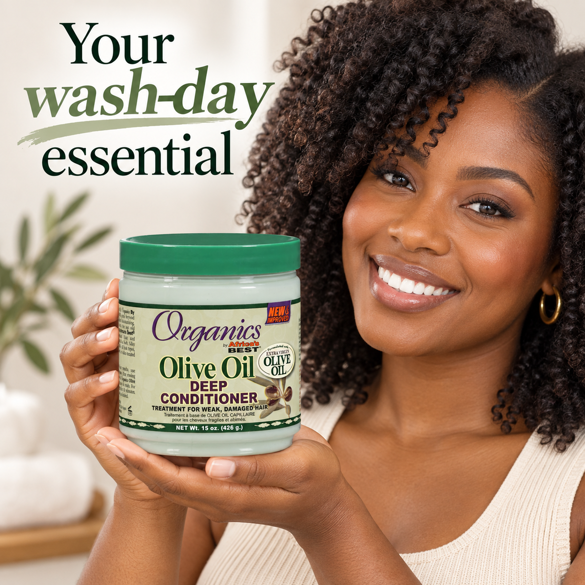A smiling woman with curly hair holds a jar of Organics Rest Olive Oil Deep Conditioner. The image features promotional text reading 'Your wash-day essential' on a bright, clean background.
