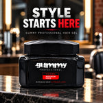 A black jar of Gummy Professional Hair Gel sits on a polished dark countertop in a barbershop-like environment, with large overlaid text reading 'STYLE STARTS HERE' above it.
