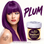 A woman with long, straight plum purple hair is shown beside a jar of La Féhé Directions semi-permanent conditioning hair colour in the shade Plum, on a white background.