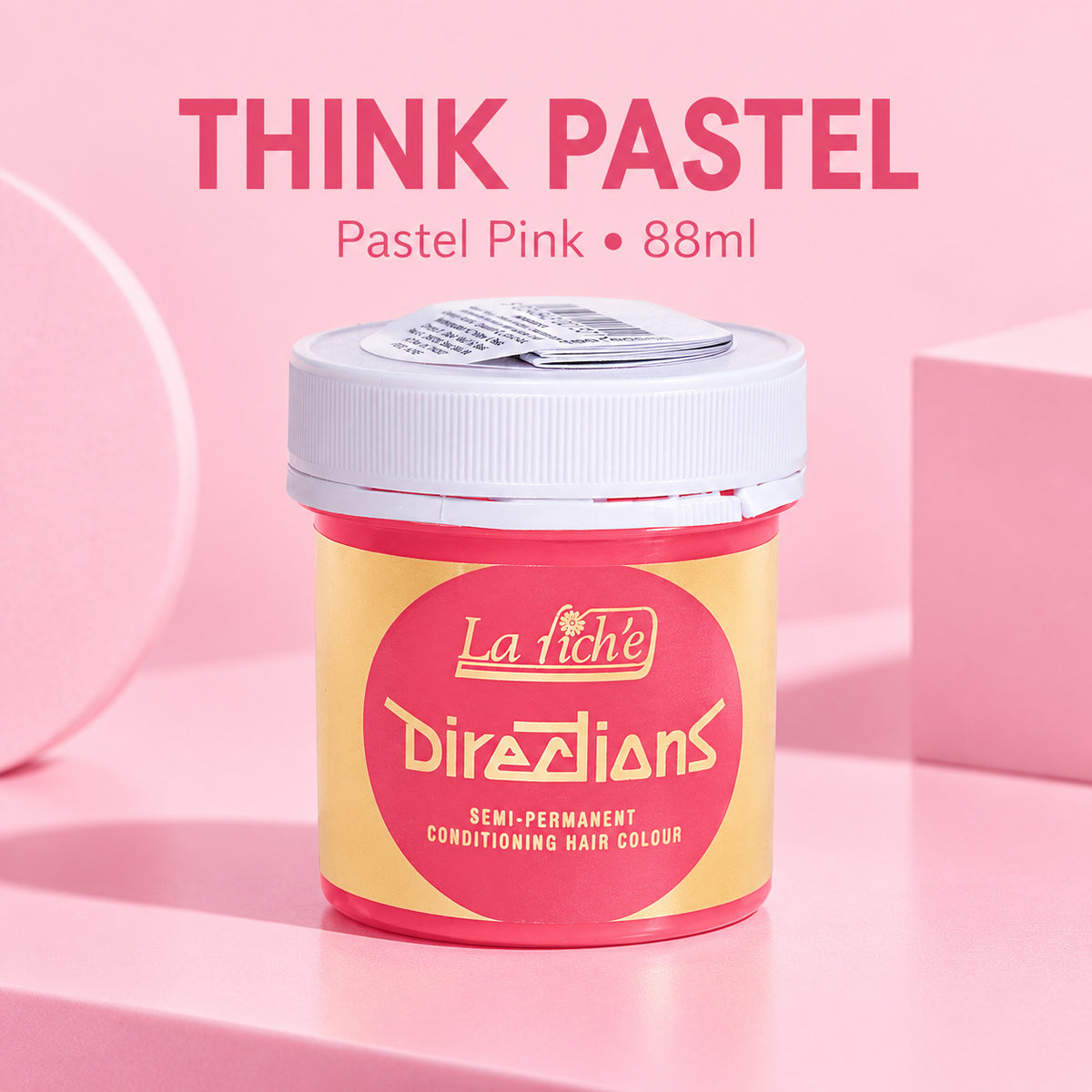 A jar of La Tiche Directions semi-permanent conditioning hair colour in the shade 'Think Pastel' (Pastel Pink), 88ml. The product is shown in a pastel pink and yellow jar with a white lid, set against a matching pink studio background with geometric shapes.
