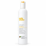 A white bottle of Milk Shake Argan Shampoo with a white cap featuring a small orange accent, set against a plain white background.
