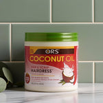 Jar of ORS Coconut Oil Hair & Scalp Hairdress on a tiled wall background
