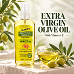 A bottle of Palmer's Olive Oil Formula Conditioning Spray Oil with Vitamin E, filled with golden yellow oil, displayed on a stone surface with green olives and a small glass bowl of oil. The background is a soft-focus olive grove with text reading 'EXTRA VIRGIN OLIVE OIL With Vitamin E'.